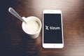 Detail shot of a smartphone with the Bizum application home screen next to a white cup of coffee. Concept of