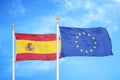 Spain and European Union two flags on flagpoles and blue cloudy sky Royalty Free Stock Photo