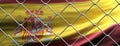 Spain flag behind steel mesh wire fence. Coronavirus pandemic quarantine, 3d illustration