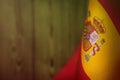 Spain flag for honour of veterans day or memorial day. Glory to the Spain heroes of war concept on lime blurred natural wood wall