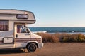 Spain; Nov 2020: Vintage caravan parked in front of the ocean, holidays and freedom feelings. Old campervan ready to sleep in it. Royalty Free Stock Photo