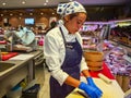 Girl cooks preparing sushi for supermarket visitors