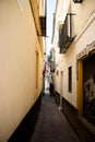 Spain, Seville, NARROW ALLEY AMIDST BUILDINGS IN CITY
