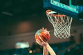 A basketball player put the ball into a basket to score points. Royalty Free Stock Photo