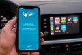 Spain Travel Health app on the screen of iphone in mans hand on the background of car dashboard screen with application