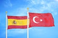 Spain and Turkey two flags on flagpoles and blue cloudy sky