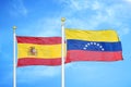 Spain and Venezuela two flags on flagpoles and blue cloudy sky