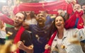 Spainian football, soccer fans cheering their team with a red scarfs at stadium. Excited fans cheering a goal Royalty Free Stock Photo