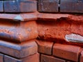 Spalling, deteriorating old exterior red brick facade detail