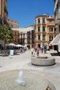 Fountains and pavement cafes in the city plaza, Malaga, Spain.