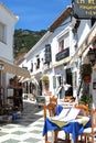 White village street with shops and cafes, Mijas, Spain.