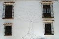 Tree painted on house wall with assorted inscriptions, Arcos de la Frontera, Spain. Royalty Free Stock Photo