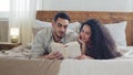 Spaniard married couple bearded husband and curly wife boyfriend and girlfriend hispanic man and woman lie on bed at