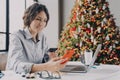 Spanish businesswoman holding credit card, doing online shopping on smartphone during Christmas time