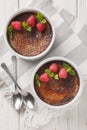 Spanish Chocolate creme brulee with caramelized sugar on top decorated with mint and raspberries close-up in a ramekin. Vertical