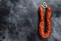 Spanish chorizo pork cured sausage. Black background. Top view. Copy space