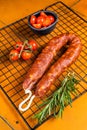 Spanish Chorizo sausage, dry cured pork with herbs and spices. Orange background. Top view Royalty Free Stock Photo