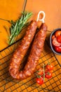 Spanish Chorizo sausage, dry cured pork with herbs and spices. Orange background. Top view Royalty Free Stock Photo