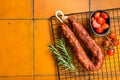 Spanish Chorizo sausage, dry cured pork with herbs and spices. Orange background. Top view. Copy space Royalty Free Stock Photo