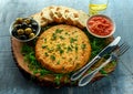 Spanish classic tortilla with potatoes, olives, tomatoes, rucola, bread and herbs.
