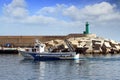 Trawler fishing boats in arrival to lighthouse in Spain.