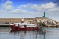 Trawler fishing boats in arrival to lighthouse in Spain.