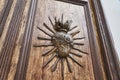 spanish colonial building with large antique wooden door with ornaments in the shape of a heart.