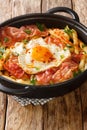 Spanish cuisine fried egg with fries and ham close-up in a plate. vertical Royalty Free Stock Photo