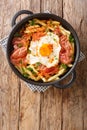Spanish cuisine fried egg with fries and ham close-up in a plate. vertical top view Royalty Free Stock Photo