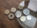 Spanish euro coins under magnifying glass on the wooden background. Local currencies