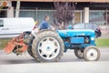 spanish Farmer rides on streets of city on farm tractor