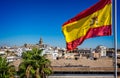 Spanish flag flying with Seville Cathedral in the background in Seville, Spain