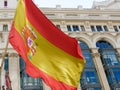 Spanish flag waving against classical buildings in Gran Via street in Madrid, Spain Royalty Free Stock Photo