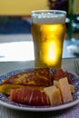 Spanish food and drink, glass of fresh beer and portion of potato omelette tortilla de patatas with onion served with cheese and