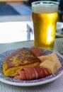 Spanish food and drink, glass of fresh beer and portion of potato omelette tortilla de patatas with onion served with cheese and