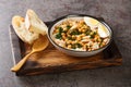 Spanish food for Easter Potaje de vigilia Chickpea stew with spinach and cod close-up in a bowl on the wooden tray. Horizontal