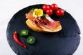 Spanish food tapas. Toasted bread with goat cheese and serrano ham decorated with peppers, kiwi and tomatoes Royalty Free Stock Photo