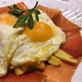 Fried egg with chips and Iberian ham. Royalty Free Stock Photo