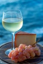 Spanish goat milk cheese with paprika coating and ripe pink table grapes served with white wine on outdoor terrace Royalty Free Stock Photo