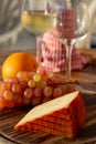 Spanish goat milk cheese with paprika coating and ripe pink table grapes served with white wine on outdoor terrace Royalty Free Stock Photo