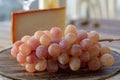 Spanish goat milk cheese with paprika coating and ripe pink table grapes served with white wine on outdoor terrace Royalty Free Stock Photo