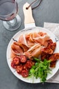 Spanish ham serrano and salami on white marbled plate an red wine. Top view. Royalty Free Stock Photo