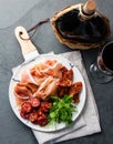 Spanish ham serrano and salami on white marbled plate an red wine. Top view. Royalty Free Stock Photo