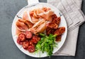 Spanish ham serrano and salami on white marbled plate. Top view. Royalty Free Stock Photo