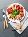 Spanish ham serrano and salami on white marbled plate. Top view. Royalty Free Stock Photo