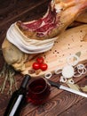 Spanish Jamon, wine bottle, tomatoes, spices, thyme and rosemary and onion rings. Close-up image