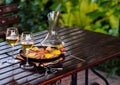 Paella in the pan with the wine on the table.