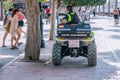 Spanish local policemen on quad bike motorcycle on tourist street. MARBELLA, MALAGA/SPAIN - JULY 21 2022