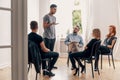 Spanish man talking with rebellious teenagers during meeting of support group