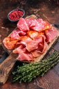 Spanish meat tapas - salami, jamon, choriso cured sausages. Dark background. Top view Royalty Free Stock Photo